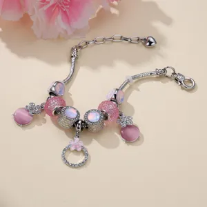 Primo piano di braccialetto di perle occhio di gatto rosa con perline di fiori argentati e strass