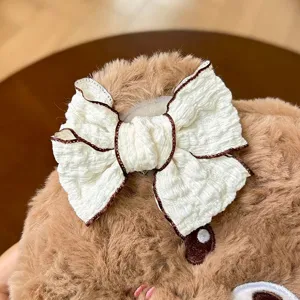 Cute plush bear pencil case with white bow detail, soft fuzzy stationery pouch for students.