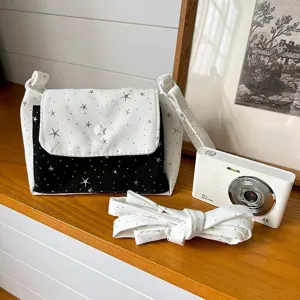 Canvas crossbody bag with star print, stylish black and white contrast shoulder bag for daily use.