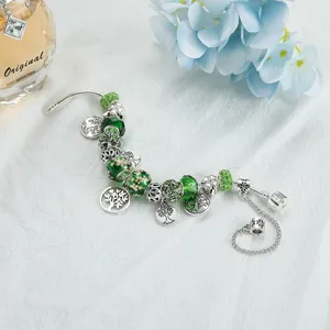 Bracciale componibile in argento con perline di cristallo verde e ciondoli albero della vita.