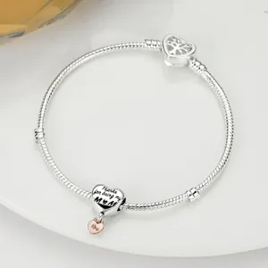 Silver snake chain bracelet with heart charm and tree of life clasp detail view.