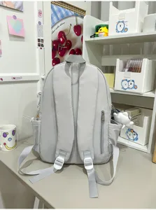 Vue détaillée de sac à dos d'école gris, design léger et grande capacité pour étudiants.
