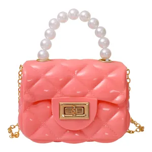 Graziosa borsa tracolla in gelatina rosa con manico di perle e catena dorata per uso quotidiano.