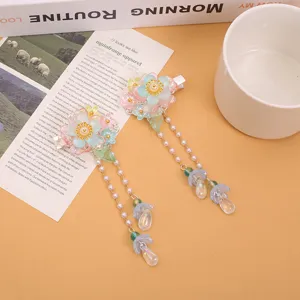 Pinzas para el pelo de estilo antiguo para ninos con flores de vidrio y borlas de perlas.