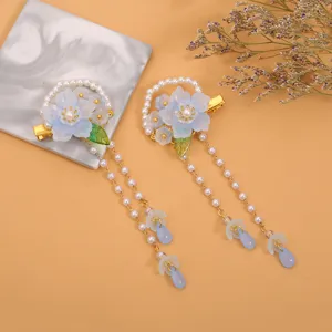 Vista detallada de pinzas para el cabello retro para niños, flores de vidrio azul y borlas de perlas.