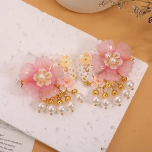 Primer plano detallado de pinzas para el cabello con flores rosas y perlas de estilo chino.