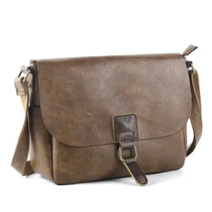 Vintage brown leather crossbody messenger bag detail view showing metal buckle and textured finish.