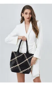 Close-up detail shot of the black and beige woven leather shoulder tote bag interior structure.