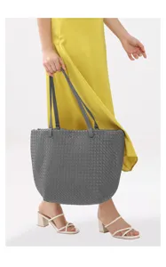 Detailed close-up view of the dark grey woven leather tote bag, showcasing texture and straps.