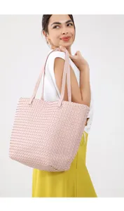 Detailed view of light pink woven leather tote bag, elegant shoulder strap design for daily use.