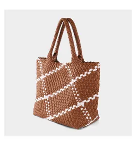 Brown and white woven tote bag detail showing the intricate handcrafted grid pattern and handles.