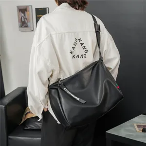 Detailansicht der stilvollen schwarzen Ledertasche, modisch getragen, zeigt Material und Gurt.