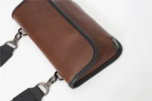 Brown PU leather crossbody bag detail shot, showing smooth texture and exquisite edge piping.