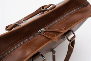 Close-up detail of vintage brown leather briefcase, showing premium metal zipper and hardware.