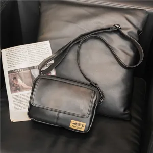 Detailed view of black PU leather crossbody bag showing front flap pocket and strap.