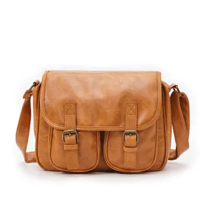 Close-up detail of the retro leather messenger bag showcasing textured material and metallic buckles.
