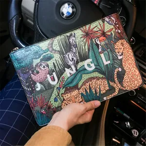 Detail view of a casual printed jungle design envelope clutch bag, showing animal art pattern.