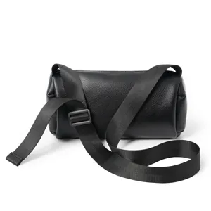 Black leather cylinder crossbody bag detail view showing sturdy strap and buckle.