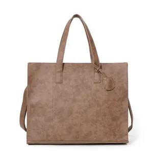 Detailed view of the stylish brown PU leather tote bag with handle and front pocket design.