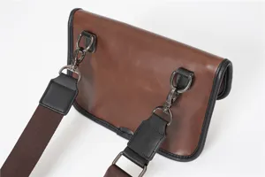 Brown PU leather crossbody bag detail showing metallic hardware, strap clips and clean stitching.