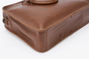 Close-up detail of a vintage brown leather men's business briefcase with metal hardware.