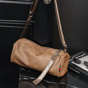 Dettaglio della borsa a tracolla cilindrica marrone in pelle morbida con cinturino elegante.