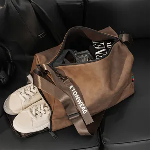 Detail view of large capacity brown leather duffel travel gym bag with separate shoe compartment.