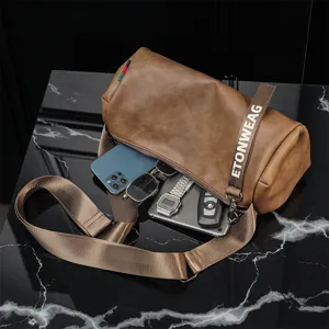 Vista dettagliata della borsa a tracolla marrone cilindrica con capiente spazio interno.