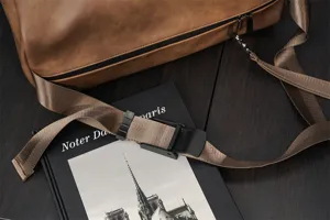 Detailed view of the brown PU leather messenger bag strap, buckle and texture, durable and stylish.