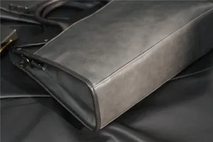 Vintage grey leather men briefcase detail, business casual tote bag with fine stitching.