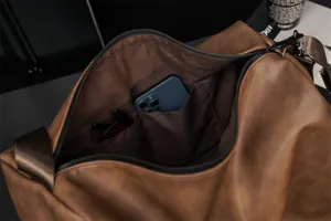 Interior detail of brown travel duffel bag with practical inner pockets for neat organization.