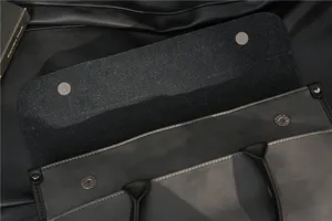 Detail view of men's vintage grey leather briefcase magnetic snap and handle craftsmanship.