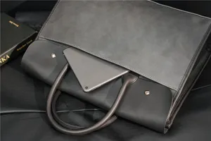 Grey leather briefcase for men, stylish business handbag with spacious interior design.