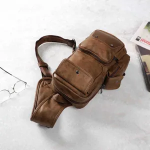 Close-up detail view of retro brown leather chest sling bag with multiple pockets and straps.
