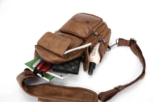Detailed view of brown leather sling bag showcasing multi-pocket capacity with inserted items.