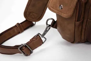Brown leather men chest bag strap detail, vintage style sling backpack hardware view.
