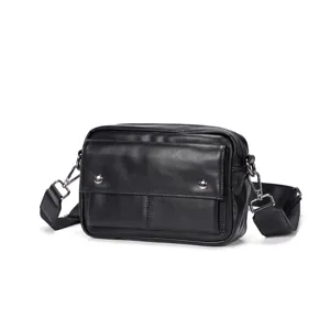 Detailed view of the black leather crossbody bag featuring front pocket and metallic hardware.