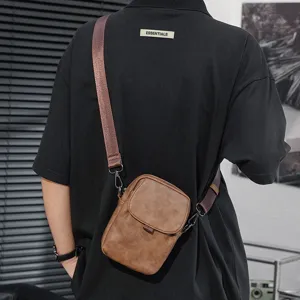 Detalle de bolso bandolera minimalista de cuero marrón, bolso casual para uso diario y viajes.