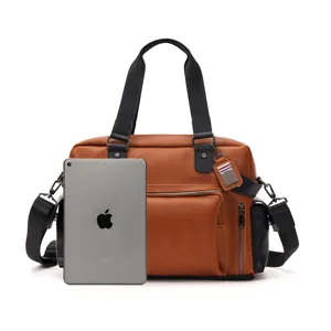 Vista dettagliata della borsa a tracolla marrone da uomo in pelle con tablet come riferimento.