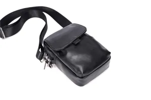 Vista detallada del bolso de hombro negro casual con correa ajustable y herrajes de metal.