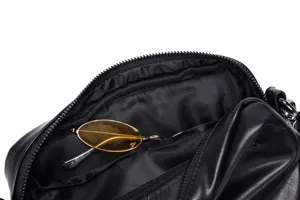 Black leather crossbody bag casual shoulder bag with zipper and yellow sunglasses prop