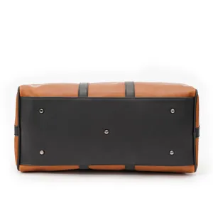 Detailed bottom view of men's retro brown duffel travel bag with protective metal feet.