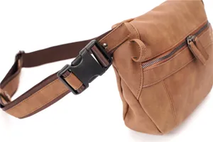 Vue rapprochée du sac de poitrine marron pour homme avec boucle solide et fermetures éclair.