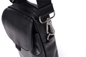 Vista detallada del bolso de hombro de cuero negro con herrajes metálicos duraderos.