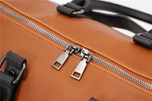 Close-up detail view of mens vintage travel bag featuring durable metal zippers and sturdy handles