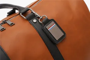 Detailed shot of vintage brown leather travel duffel bag with black straps and hardware.