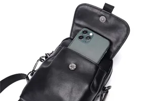 Vista detallada del mini bolso de cuero negro, mostrando el espacio de almacenamiento y cierre.