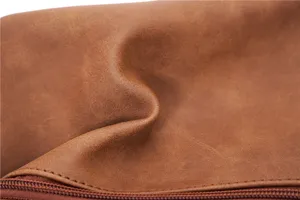 Détail de sac de poitrine en cuir marron vintage, texture de qualité et fermeture éclair.
