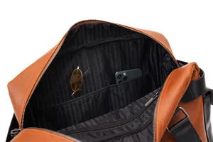 Dettaglio interno della borsa da viaggio in pelle marrone da uomo con tasche interne.