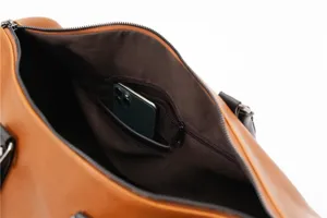 Interior detail view of the retro leather travel duffel bag showing storage pockets and phone slot.